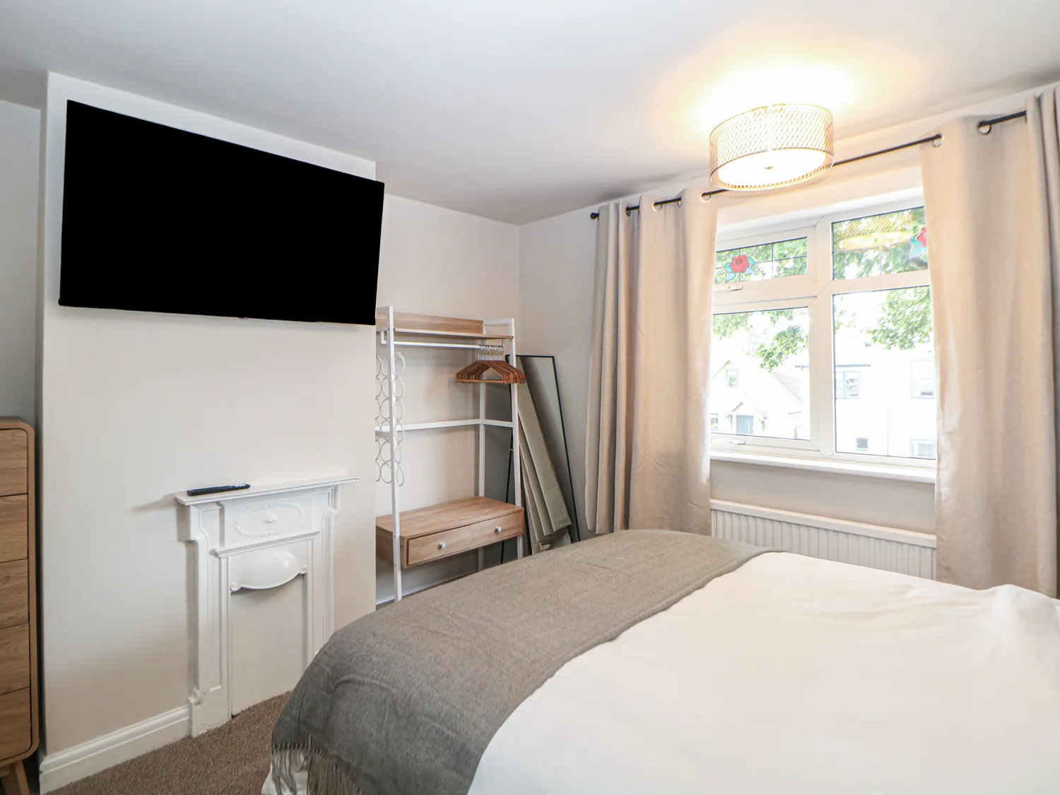 Double bedroom with wall-mounted TV and bay window