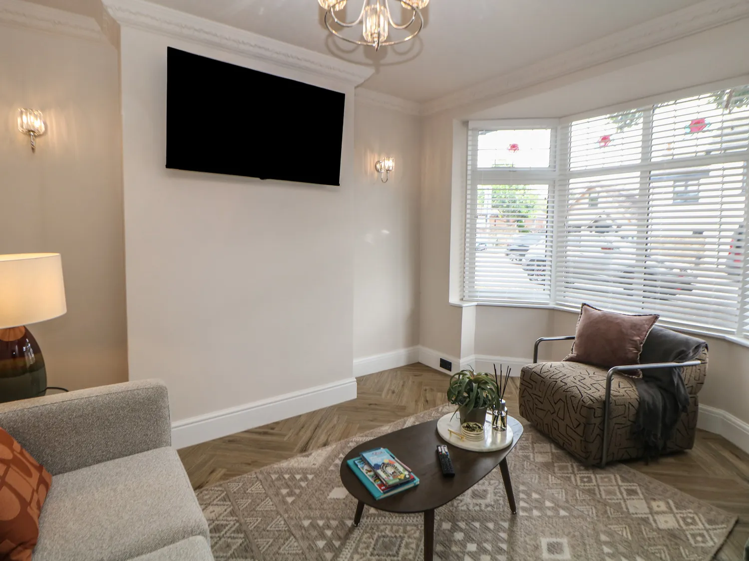 Second lounge angle with wall-mounted smart TV and patterned armchair