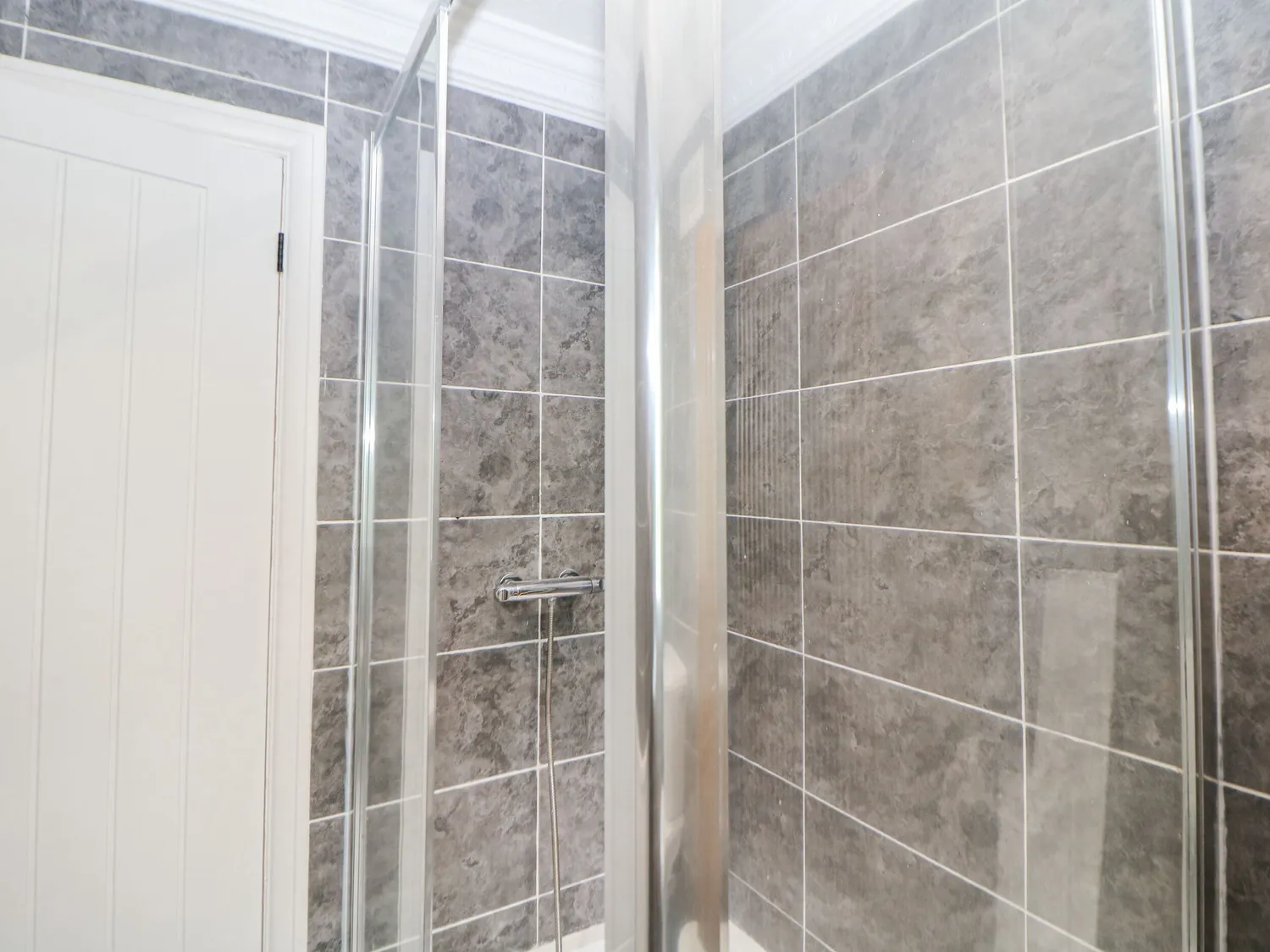 Shower room with grey marble-effect tiles and glass enclosure