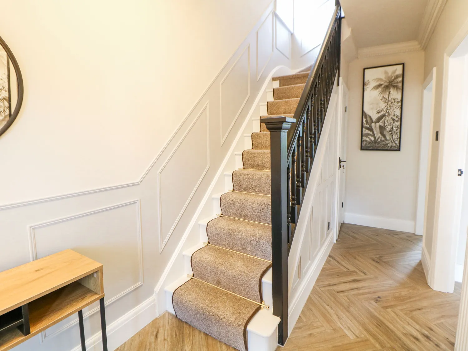 Panelled staircase with black balustrade and stair runner