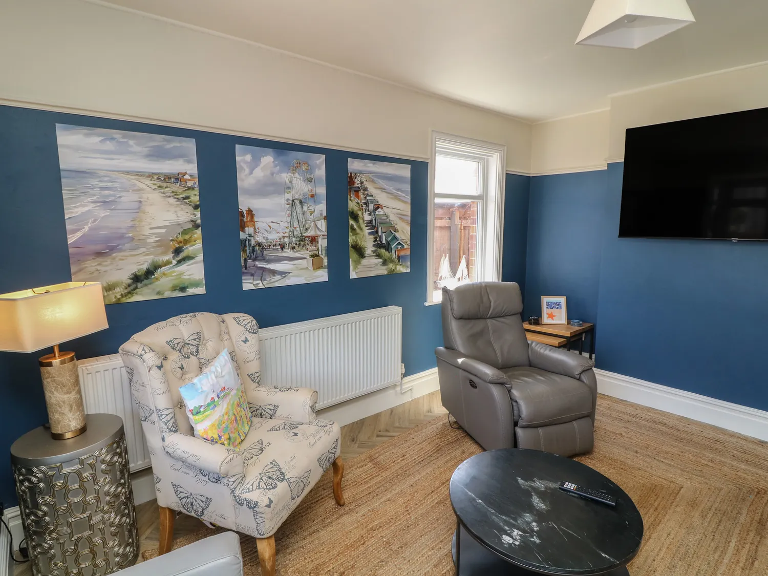 Sitting room with deep-blue walls, recliner and seaside art