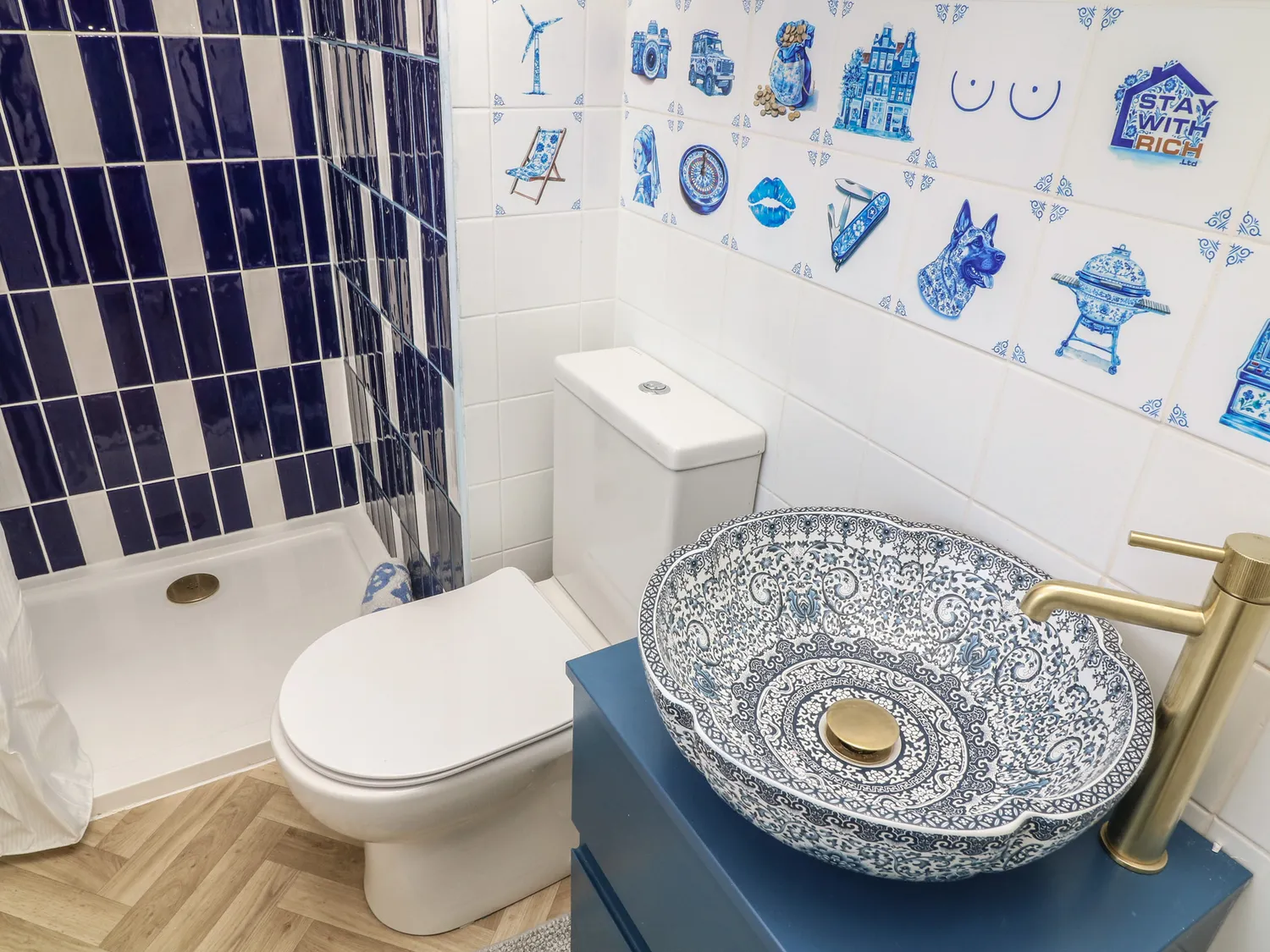 Blue and white tiled shower room with patterned basin and bespoke Delft tiles
