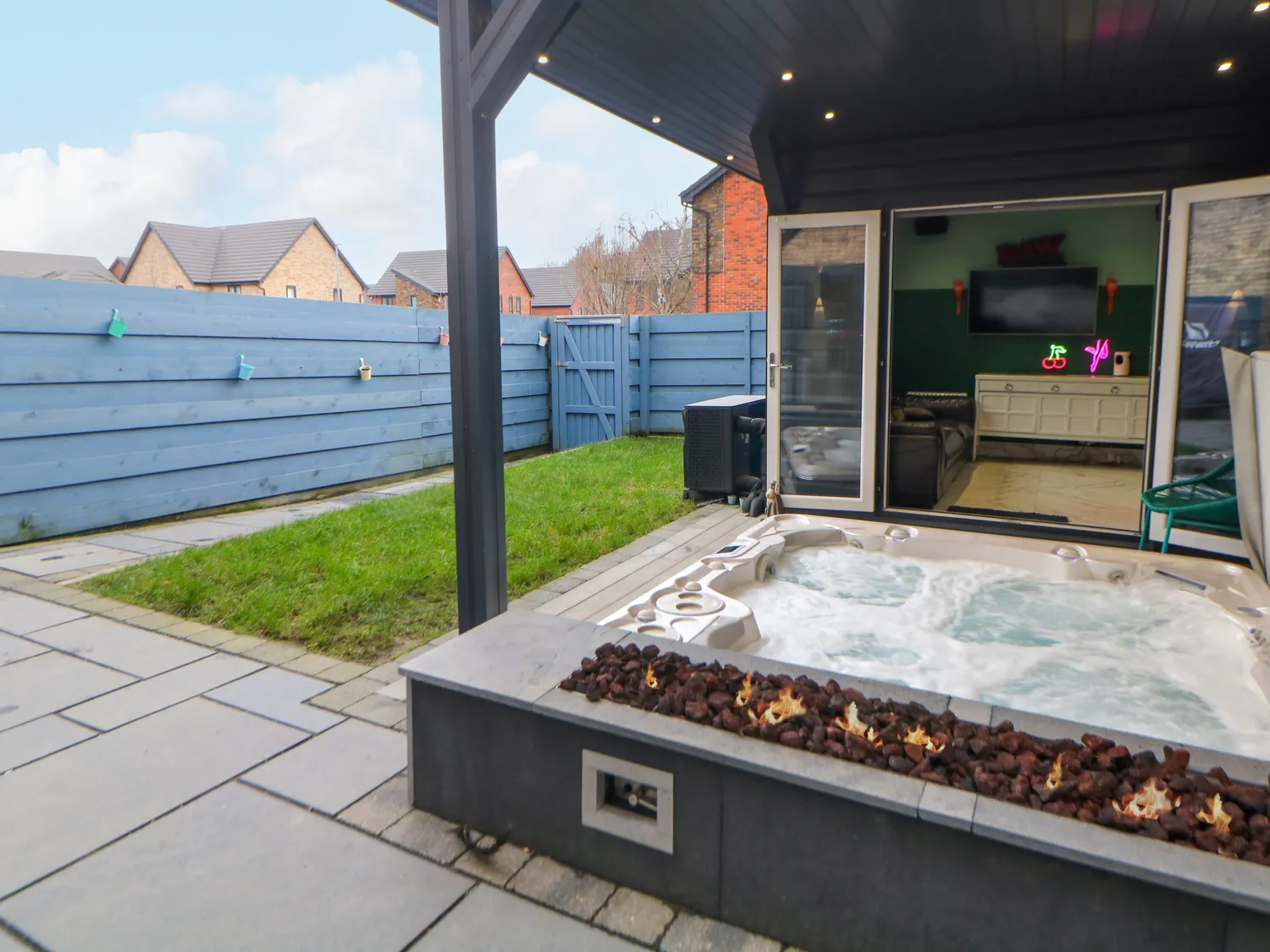 Hot tub with lava-rock firepit beneath the covered summerhouse