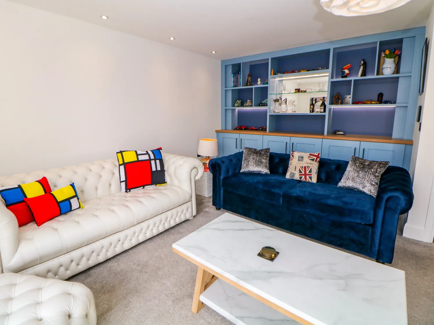 Second sitting room with chesterfield sofas and bespoke shelving